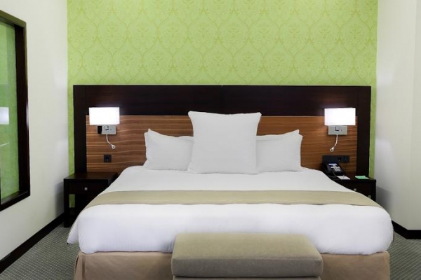 سرير غرفة جناح جونيور في فندق كورب عمان